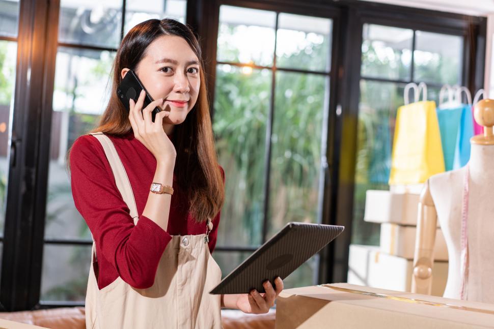Free Stock Photo of Female shop owner calling to customer and checking