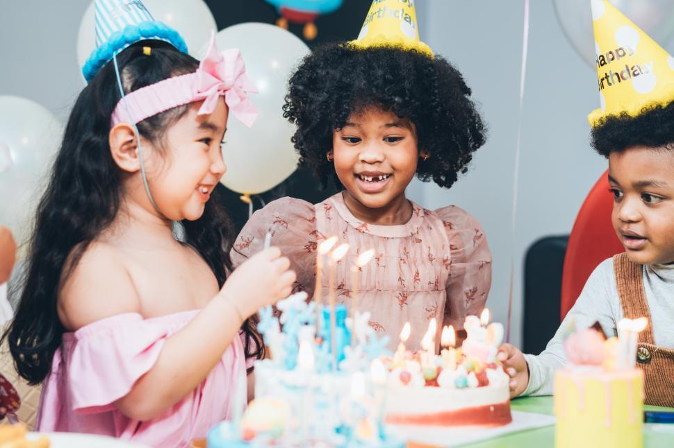 Multiethnic group of kids enjoy having birthday