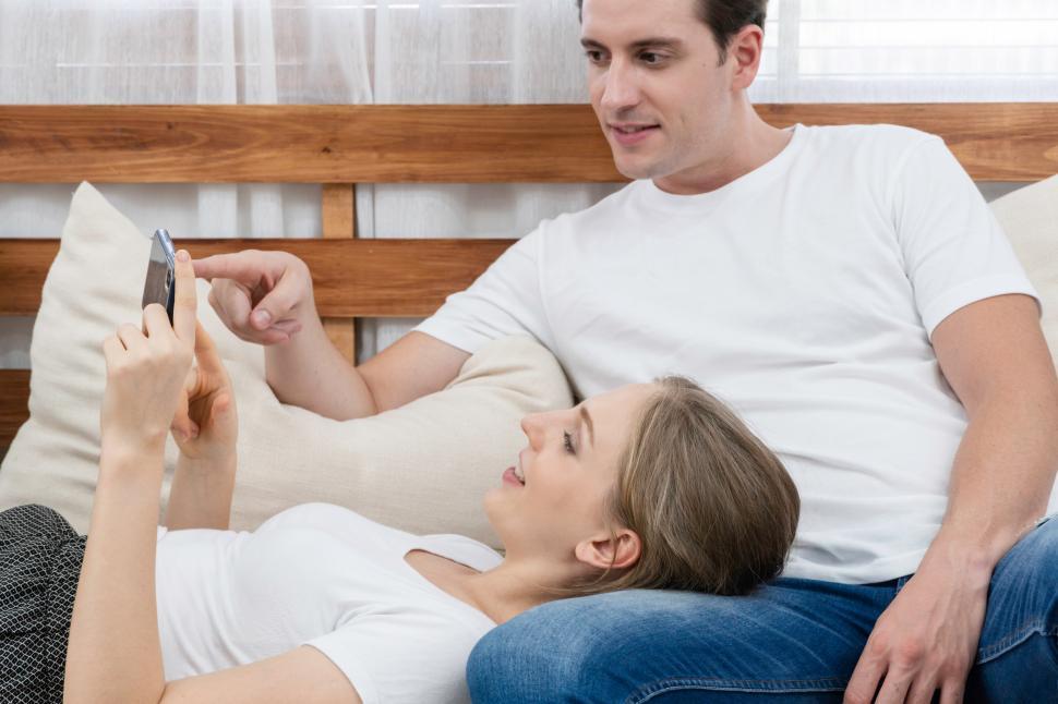 Free Image of Happy couple playing  on mobile phone in the living room 