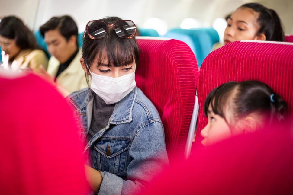 Free Image of Mother talking with daughter at a seat on airplane 
