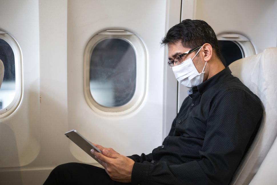 Free Stock Photo of Asian businessman using digital tablet on airplane