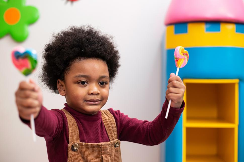 Free Stock Photo of Happy boy with candy in playroom Download Free