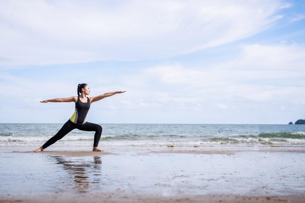 Free Stock Photo of young woman is stretching or doing yoga at the beach