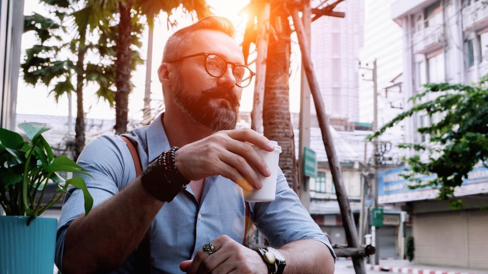 Free Image of Man with cup of coffee sitting in an outdoor cafe 