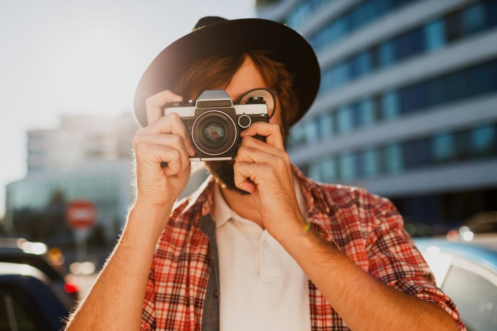 Free Image of Fashionable bearded man portrait, using retro film photo camera 