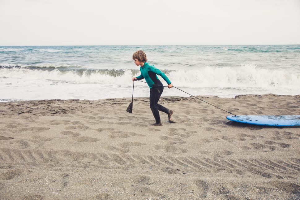 Free Image of kid learning to surf on the beach 