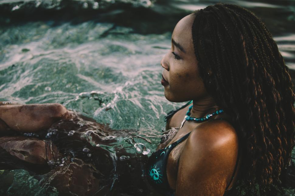 Young woman taking bath in sea during sunset stock photo