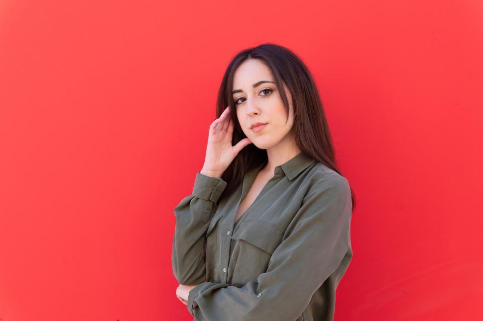 Free Image of Woman wearing a green shirt on red background 