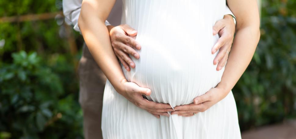 Free Image of Happy man hugging his pregnant wife's belly 