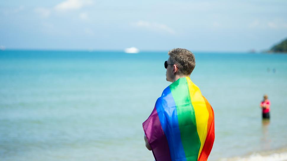 Free Stock Photo of LGBT travel concept. Man on the beach draped in