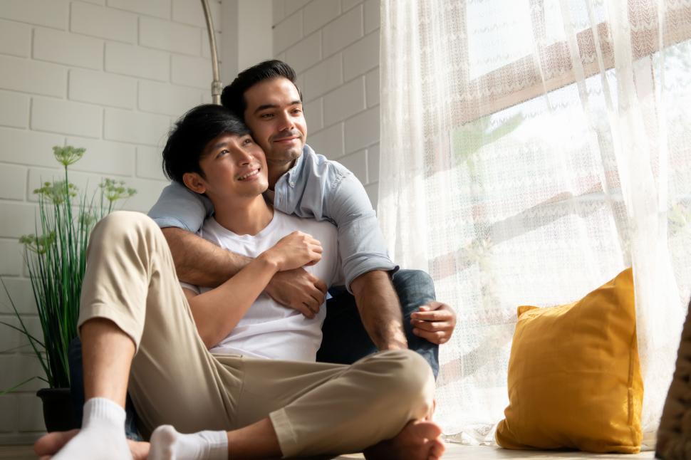 Couple relax together at home - man and his boyfriend or husband at home