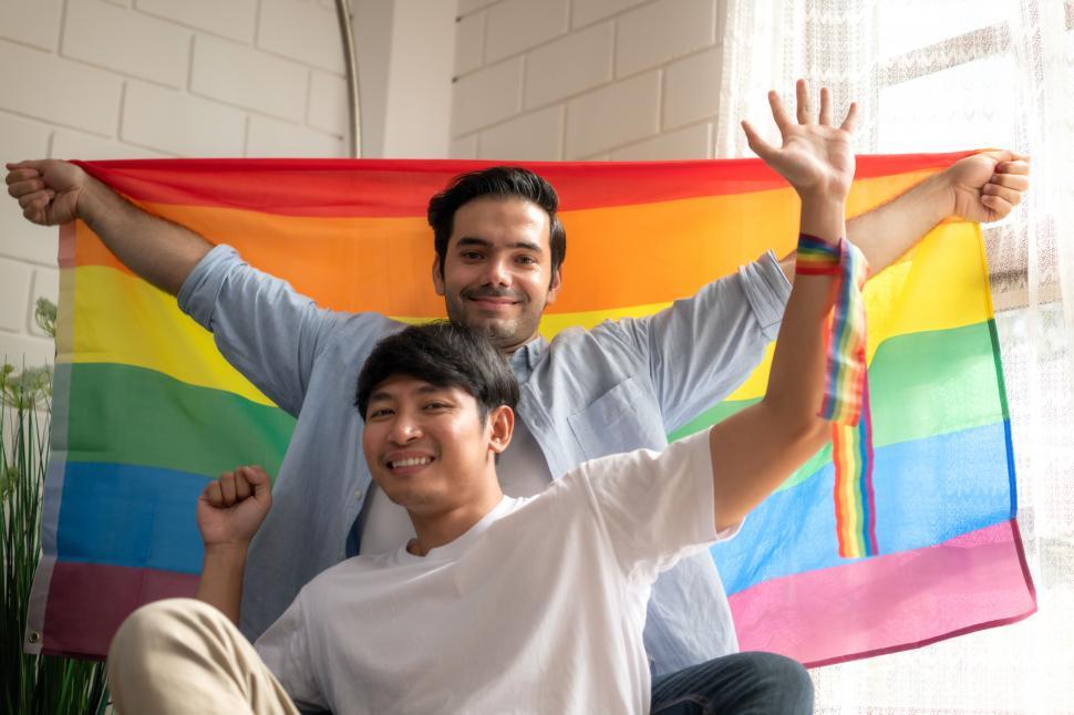 Two proud gay men holding a rainbow pride flag