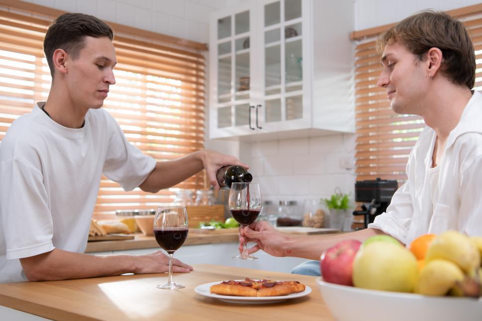 LGBT Young couple celebrate the day of love between each other with glass of wine