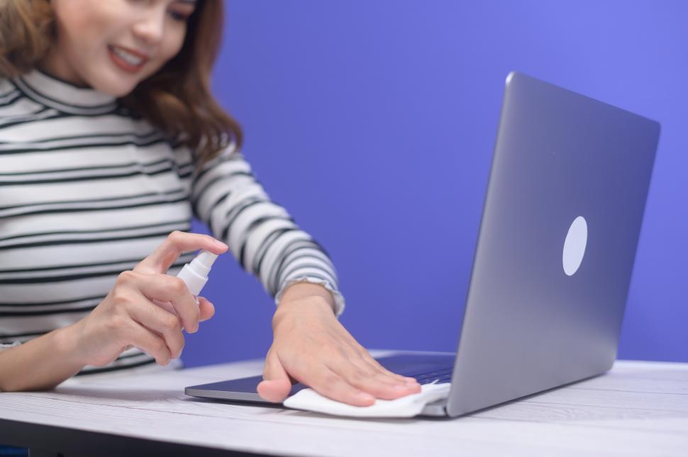 Free Stock Photo of Woman with sanitizing alcohol spray for computer