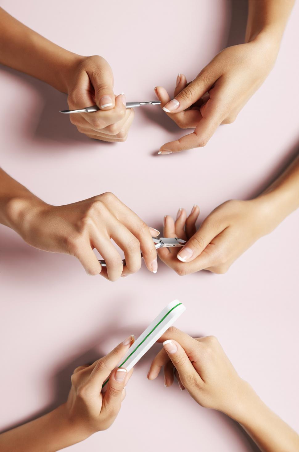 Free Image of Three sets of hands receiving manicure treatment 
