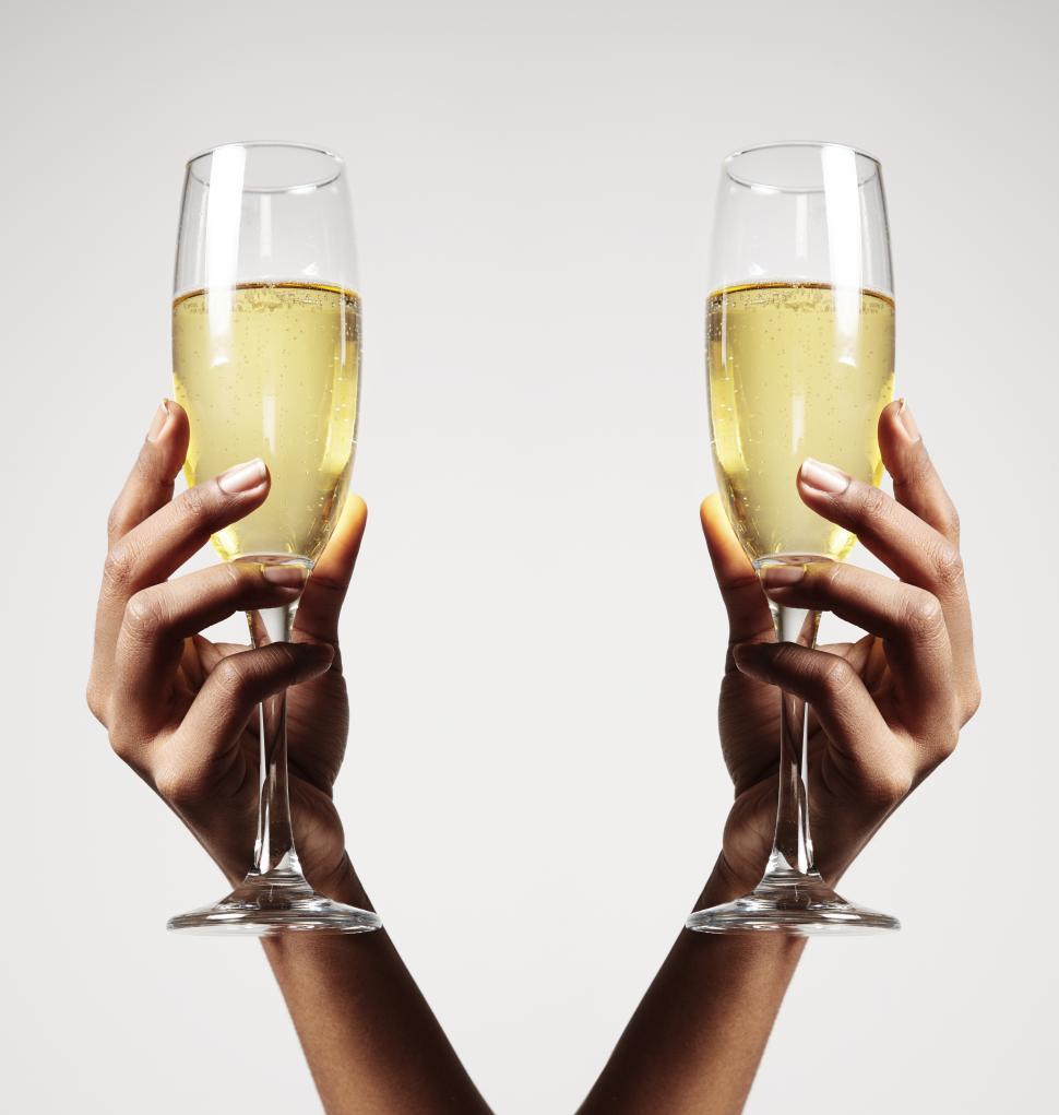 Free Image of two arms holding up two glasses of champagne 