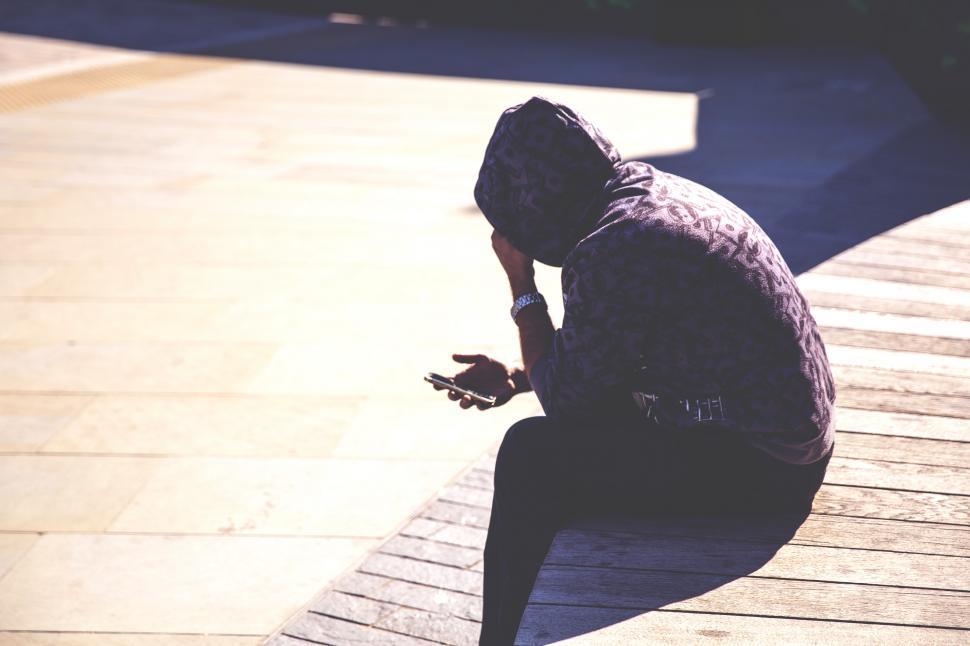 Free Image of Hoodie Man Checks Phone Free Stock Photo 