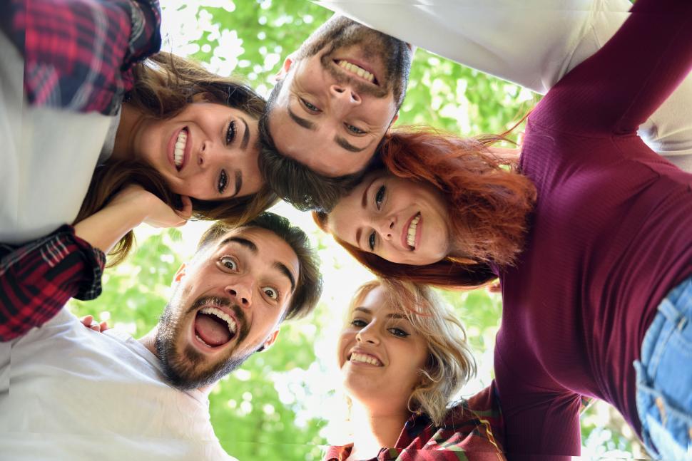 Free Image of Group of young people looking down together outdoors in urban background 