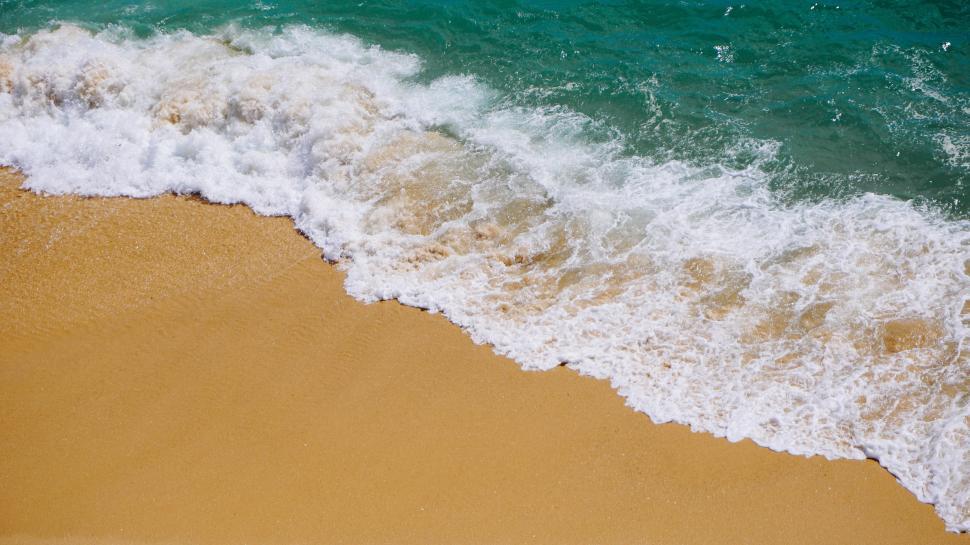 Beach sand sea water summer background. Sand beach desert texture. White  foam wave sandy seashore top view Stock Photo