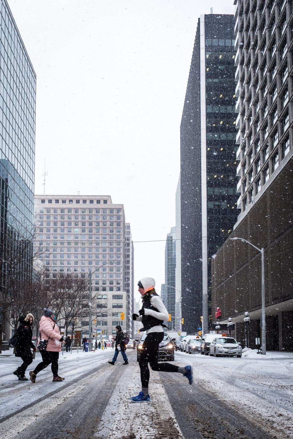Free Image of A person walking on a street in the snow 