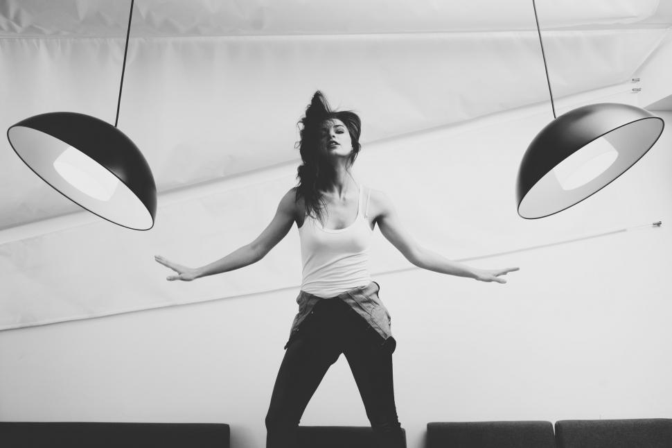 Free Image of A woman standing in a room with two black lamps 