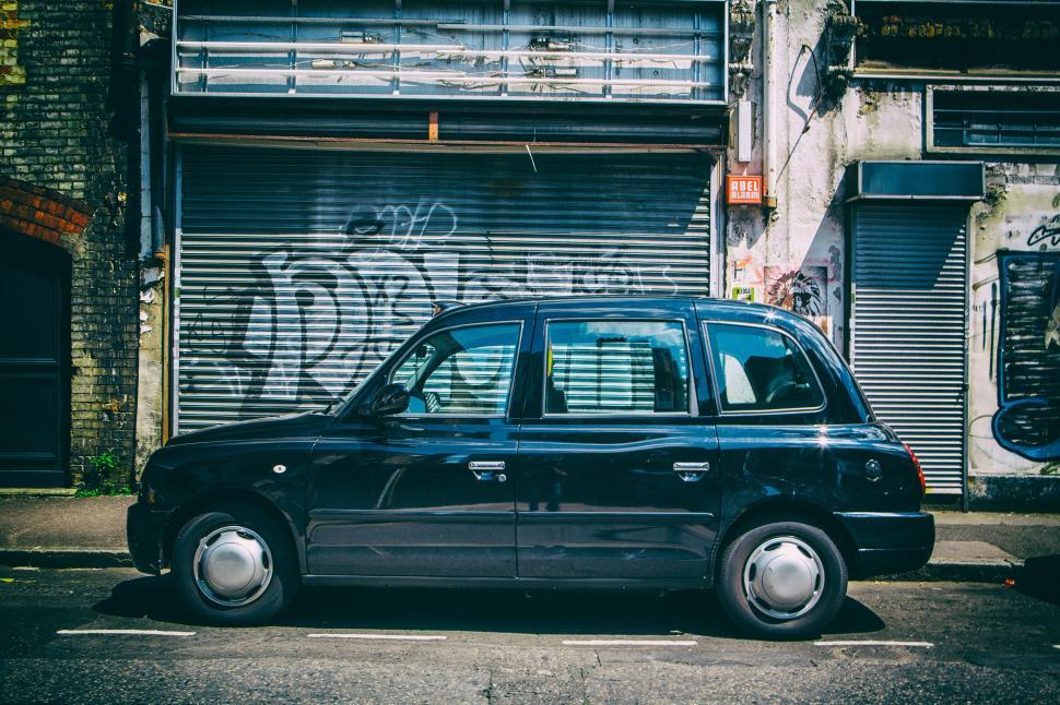 Free Image of A black car parked on the side of a road 