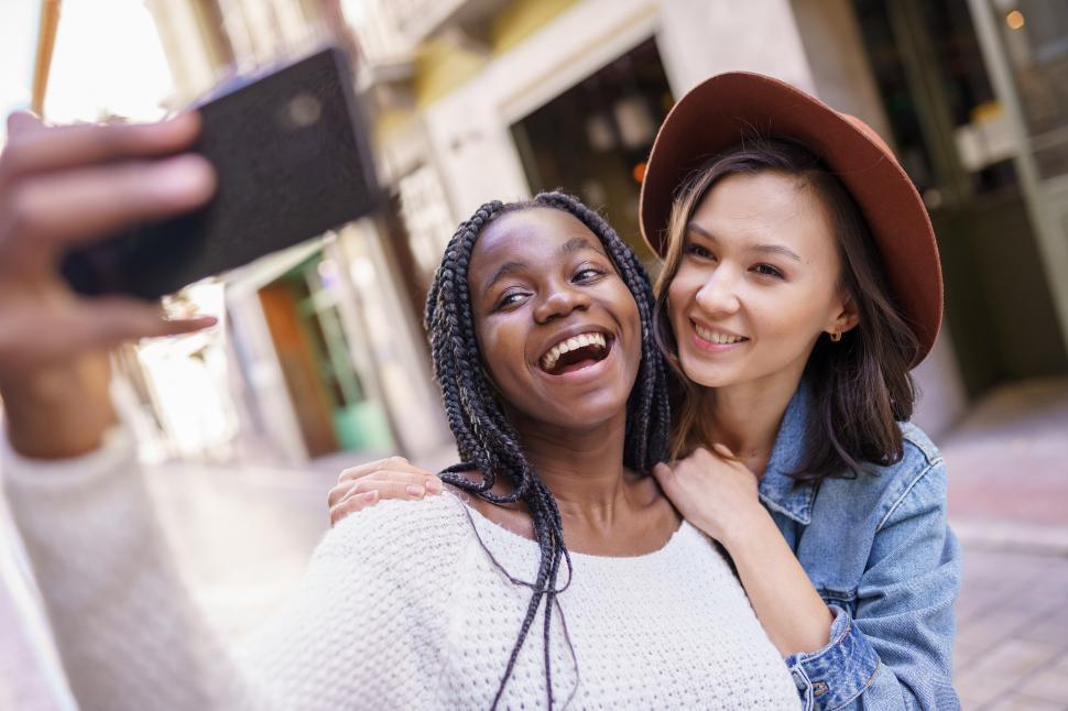 Free Image of Two beautiful multiethnic women making selfie and grimacing 