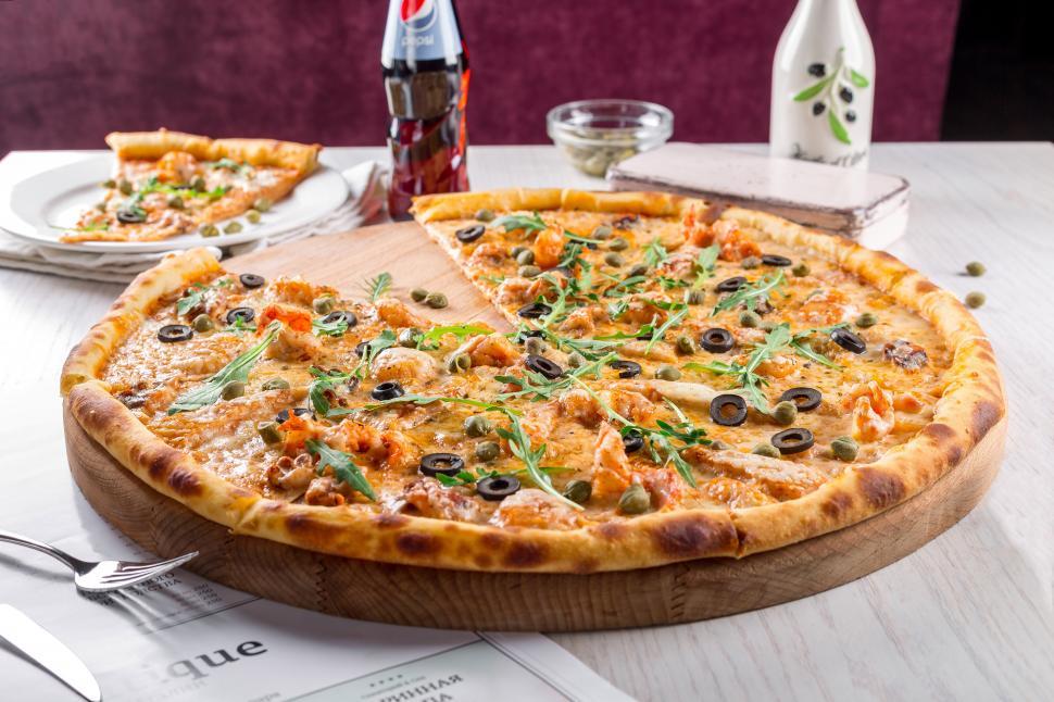 Free Image of A pizza on a wooden plate 