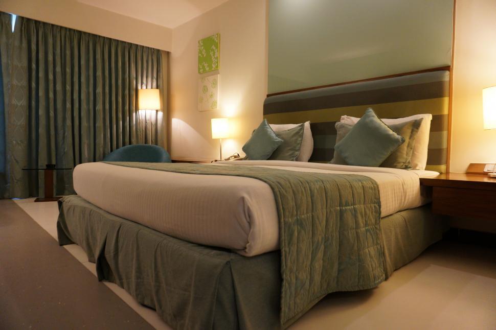 Free Image of A bed with pillows and a lamp in a room 