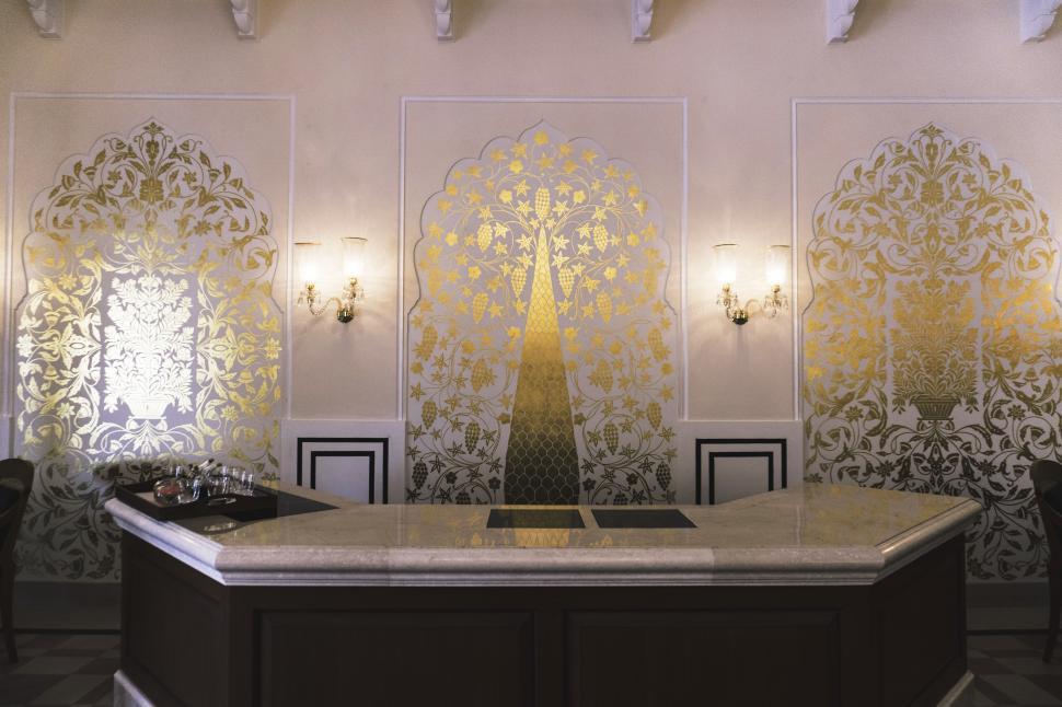 Free Stock Photo of A reception desk with a gold patterned wall