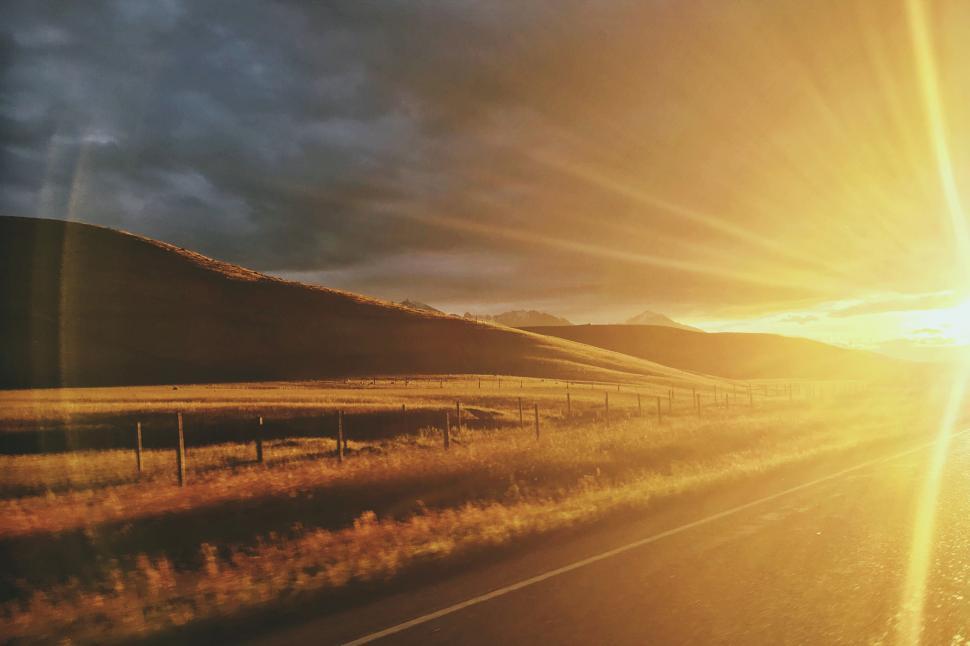 Free Image of A road with grass and a fence in the middle 