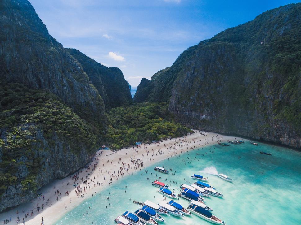 Free Image of A beach with boats and people on it 