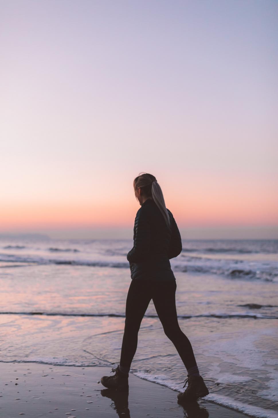 Free Image of A woman walking on a beach 