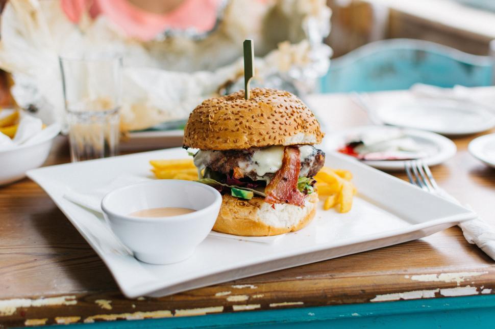Free Image of A burger with fries and sauce on a plate 