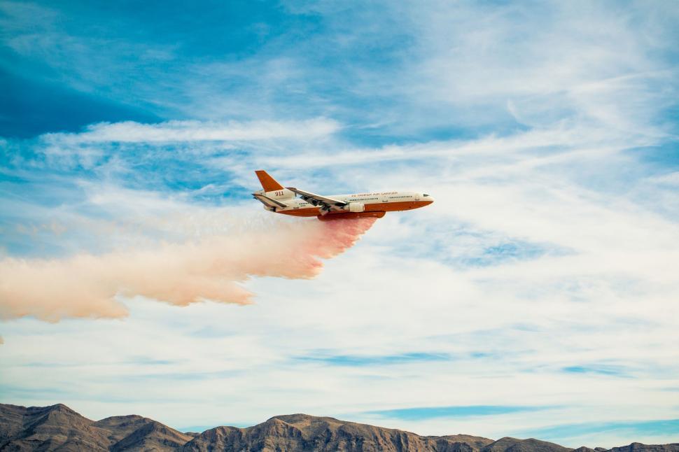 Free Image of An airplane flying in the sky with a trail of smoke 