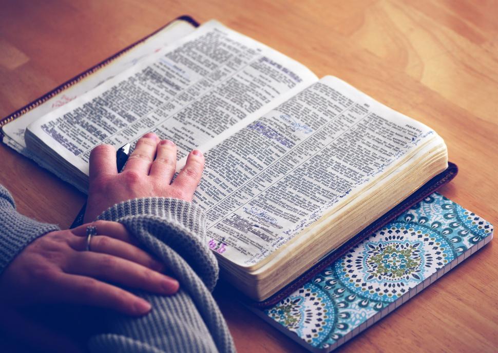 Free Image of A person s hand on a book 