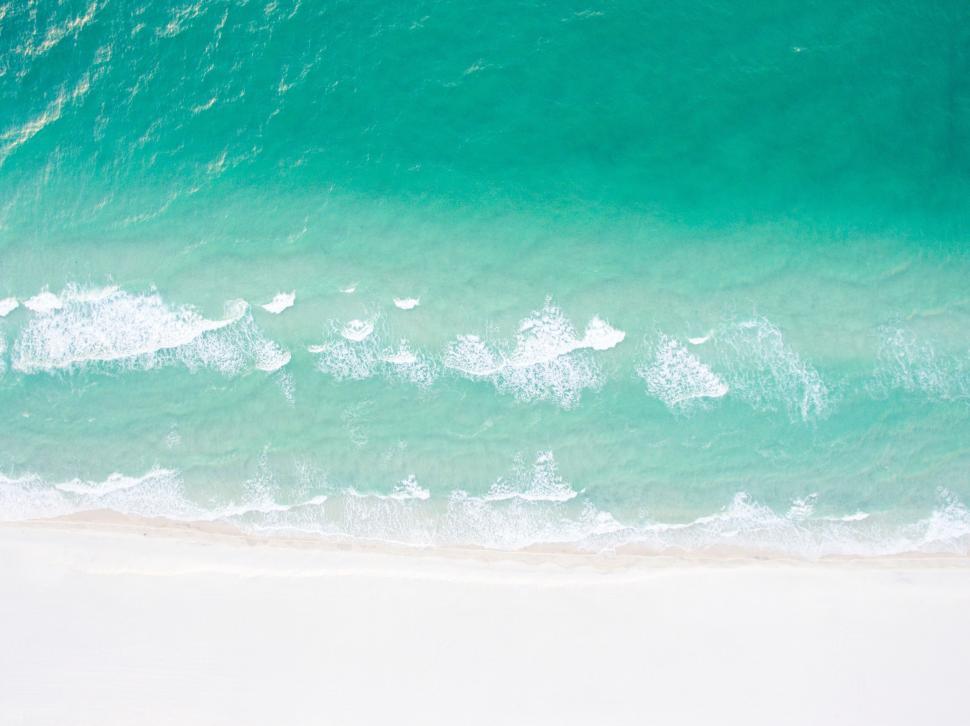 Free Image of A beach with blue water and sand 