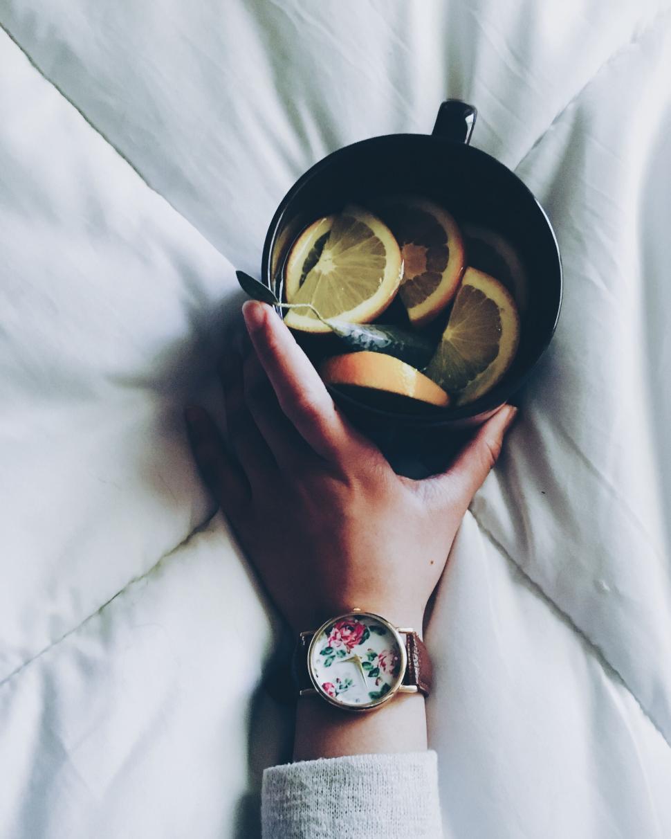 Free Image of A hand holding a bowl of lemons 