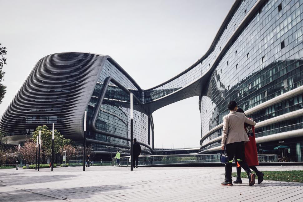 Free Image of A man and woman walking in front of a building 
