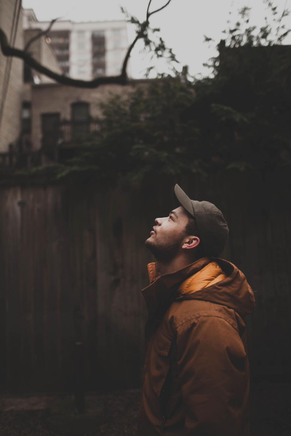 Free Image of A man in a hat looking up 