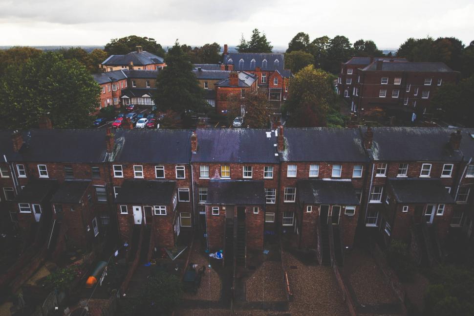 Free Image of A group of buildings with trees and a cloudy sky 