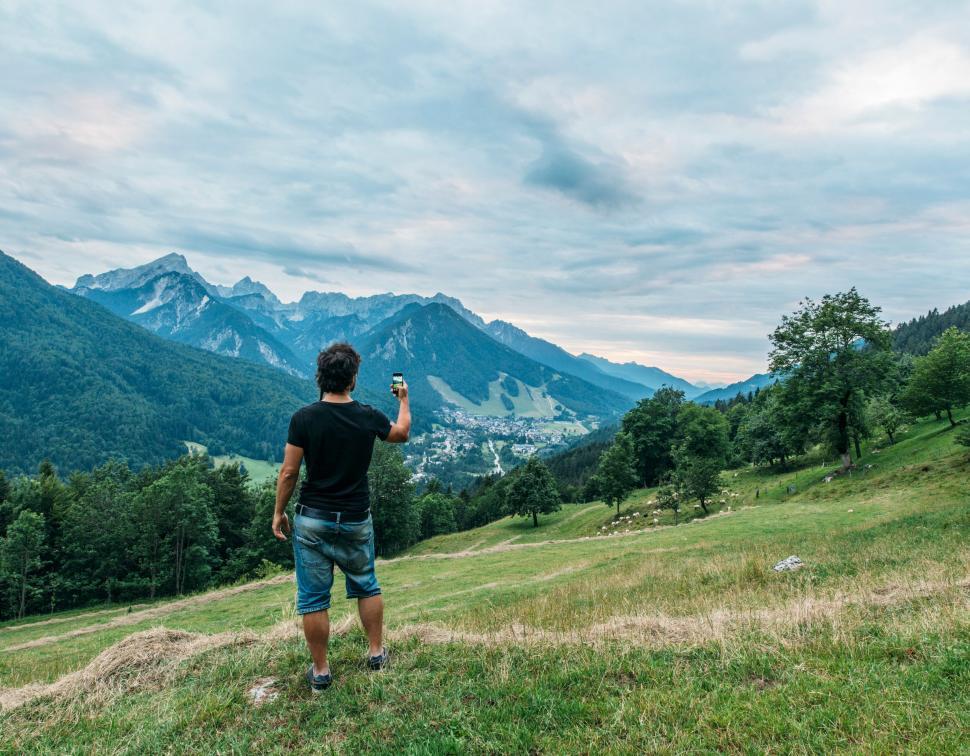 Free Image of A man standing on a hill with a phone in his hand 