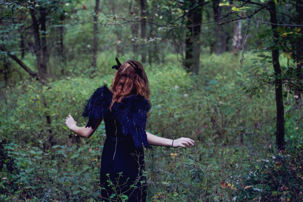 Free Image of A woman in a black dress in a forest 