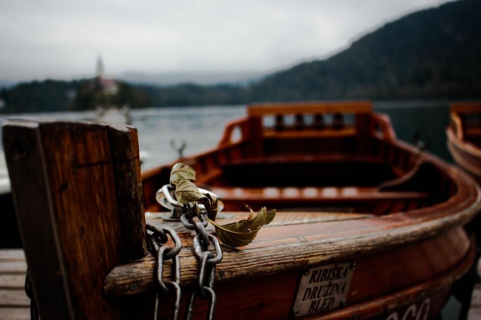 Free Image of A chain on a wooden post with a leaf on it 