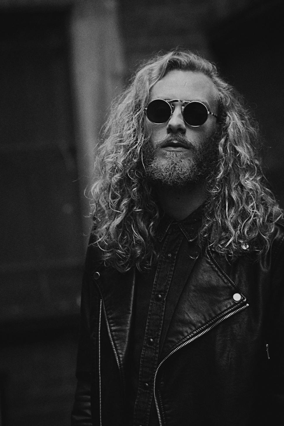Free Image of A man with long curly hair wearing sunglasses 