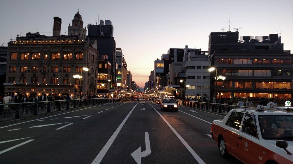 Free Image of A street with cars and buildings in the background 