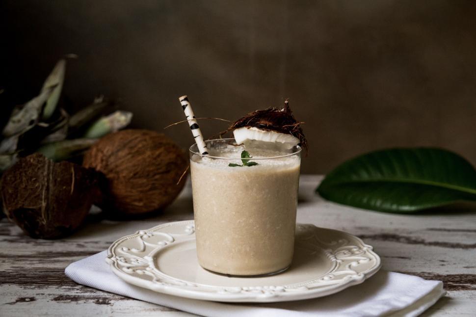 Free Image of A glass of milkshake with coconuts on top 
