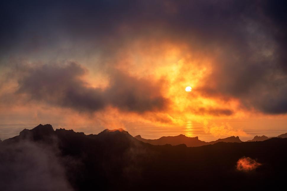 Free Image of A sunset over a mountain range 