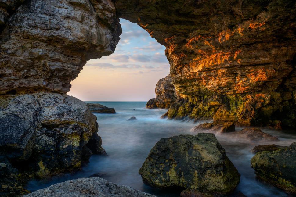 Free Image of A rock formation with a body of water in the background 