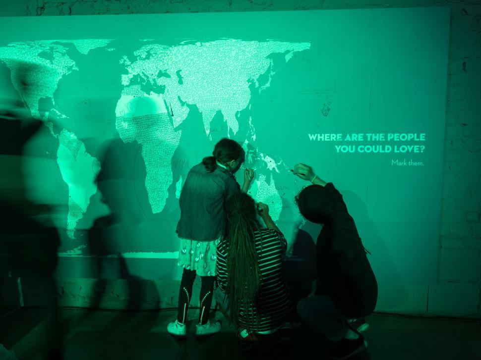 Free Image of A group of people standing in front of a large map 